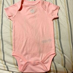 Little Me Pink Onesie with snaps has small flower on the chest.